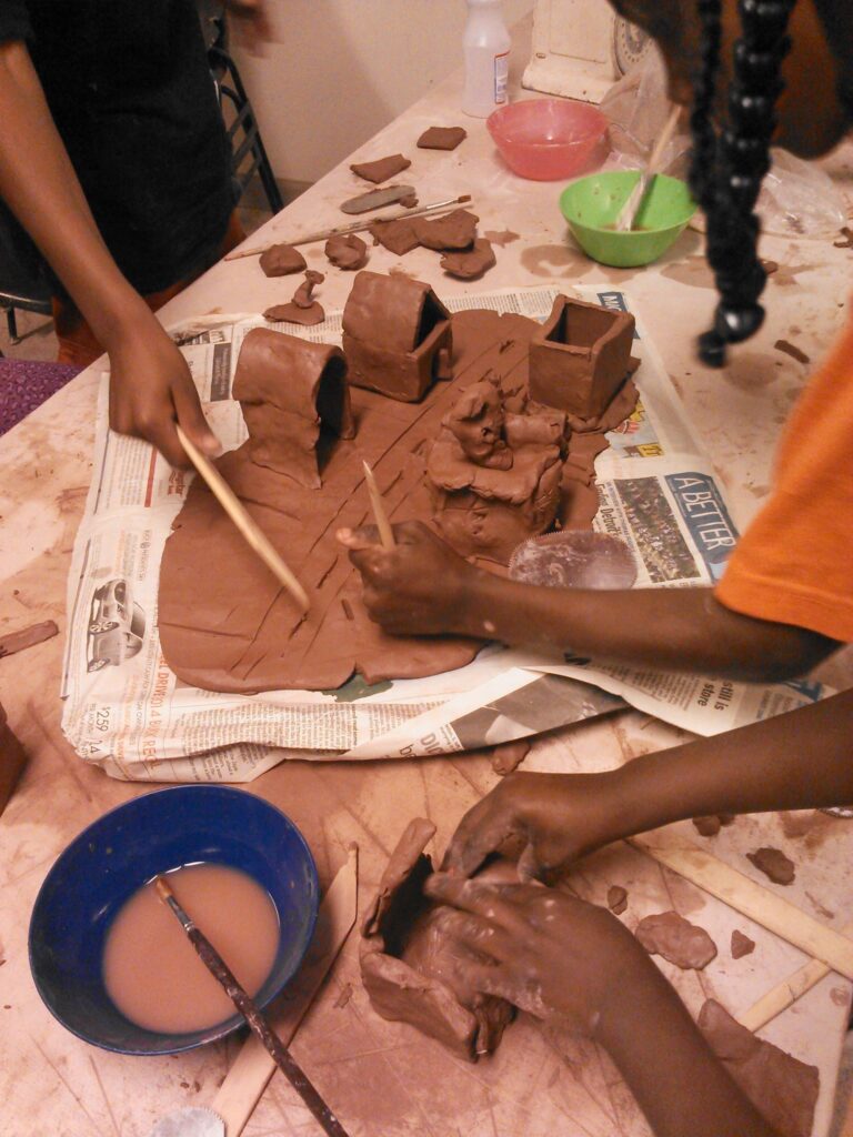 Students moulding a clay neighborhood