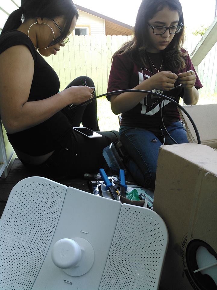 Two Equitable Internet Initiative employees preparing wires for an Internet installation