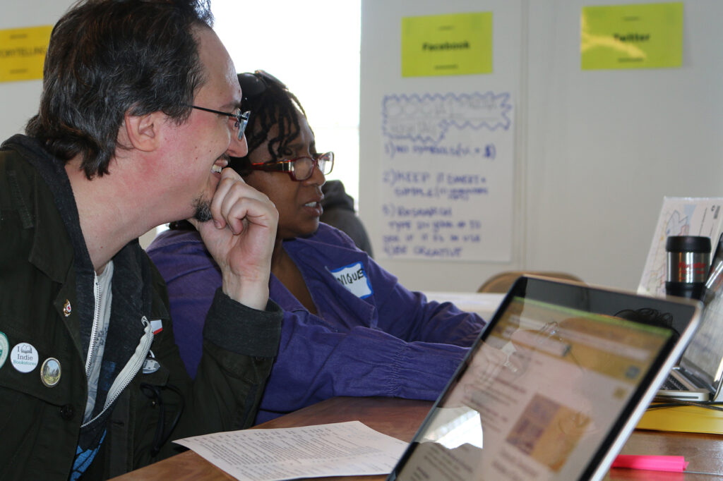 Monique at a computer showing something to another person watching their screen